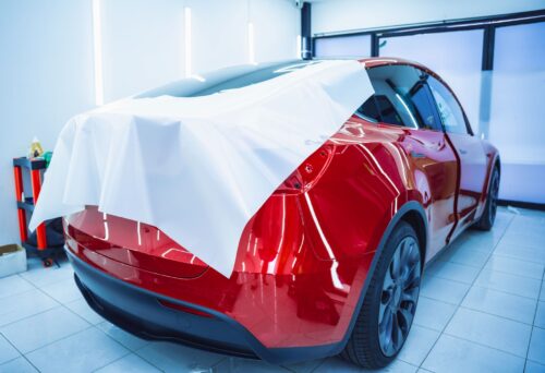 The process of installing protective film on the new red car